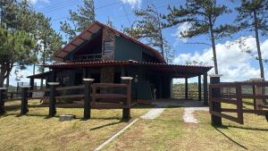 a small house with a fence in front of it at Windwood Cabin Cerro Azul in Los Altos de Cerro Azul