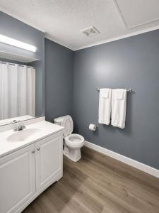 a bathroom with a white sink and a toilet at Sunwestern Suites in Douglasville +11 photos