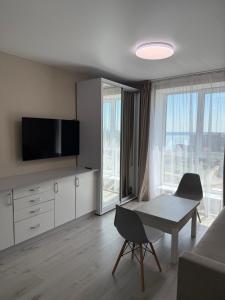 a living room with a table and a tv at Студия с Видом на Море, 9-2 in Chornomorsk