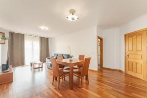 a living room with a table and chairs and a couch at One-Bedroom Apartment near Reis Magos Beach in Caniço +14 photos