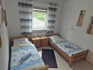 zwei Betten in einem Zimmer mit Fenster in der Unterkunft Ferienwohnung Emira in Wittingen