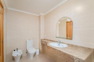 a bathroom with a toilet and a sink and a mirror at One-Bedroom Apartment near Reis Magos Beach in Caniço