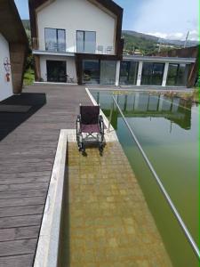 a chair sitting on a dock next to a body of water at Quinta da Sra Marocas in Covilhã