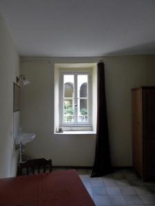 a bedroom with a window and a bed and a table at Tornoallariva b&b in Torno