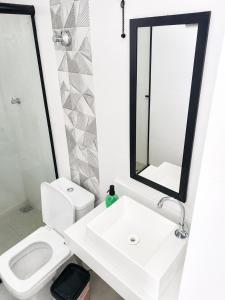a bathroom with a sink and a toilet and a mirror at Alphaville Studios in Pirapora +8 photos
