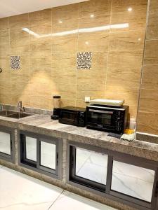 a kitchen counter with a microwave and a sink at Appartement spacieux et confortable in Abidjan