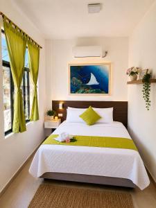 a bedroom with a bed with a green and white blanket at Hostal Gardner in Puerto Ayora