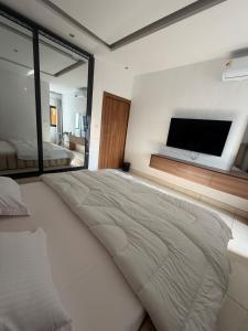 a bedroom with a large bed with a flat screen tv at Appartement spacieux et confortable in Abidjan