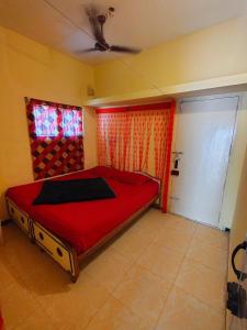 a bedroom with a red bed and a window at AKS Cottage in Yercaud +5 photos