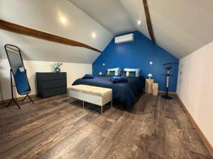 a blue bedroom with a bed and a blue wall at Sarments et Bulles in Ambonnay