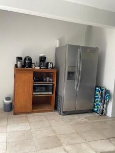 a kitchen with a stainless steel refrigerator and a wooden cabinet at Studio agnes in Palm-Eagle Beach