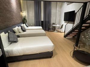 a hotel room with two beds and a staircase at Atelier Hotel Permas in Johor Bahru