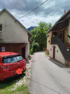 a red car parked on the side of a road at Apartma Silvester in Bovec