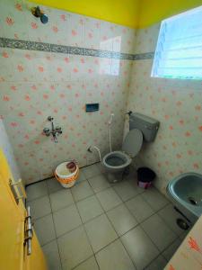 a bathroom with a toilet and a sink at AKS Cottage in Yercaud