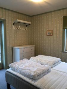 1 Schlafzimmer mit 2 Einzelbetten und einer Kommode in der Unterkunft Gästgivars vandrarhem och B&B in Järvsö