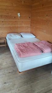 a bedroom with two beds in a wooden wall at Hjemstavnsgårdens Camping & Cottages in Glamsbjerg