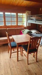 a room with a table and two chairs and a bunk bed at Hjemstavnsgårdens Camping & Cottages in Glamsbjerg +26 photos
