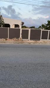 a fence on the side of a road with a house at Studio agnes in Palm-Eagle Beach