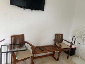 a living room with two chairs and a table and a fan at Studio agnes in Palm-Eagle Beach