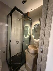a bathroom with a glass shower with a sink at Point Pyramids View in Cairo +228 photos