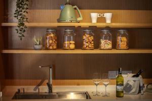 a kitchen counter with jars of food and wine glasses at Atelier Hotel Permas in Johor Bahru