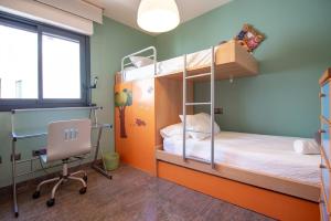 a room with two bunk beds and a desk and a chair at Plaza España - Nerja centro in Nerja