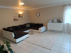 a living room with a couch and a clock on the wall at Gemütliches Apartment im Naturpark Rhein-Westerwald in Raubach