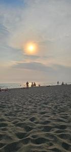 a group of people on the beach at sunset at Sabina Olive bungalow in Ulcinj +4 photos