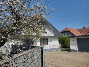 a white house with a fence and a flowering tree at Apartament Flora in Mahlberg