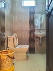 a bathroom with a toilet and a sink at Hotel Strawberry Grand in Rāmeswaram