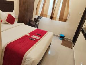 a hotel room with a bed with a red blanket at Hotel Strawberry Grand in Rāmeswaram