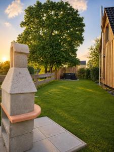 a stone bench in a yard with a tree at Gemütliches Haus am Land mit privatem Whirlpool in Schwasdorf
