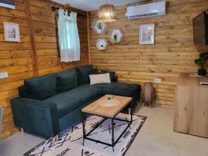 a living room with a green couch and a table at PARADISO pool&house in Prosek