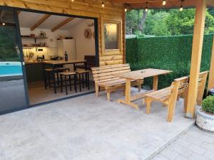 a patio with benches and a table and a kitchen at PARADISO pool&house in Prosek