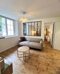a living room with a couch and a table at Nid d argile - appartement neuf - 650m des Thermes - 1er étage in Salins-les-Bains