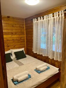 two beds in a room with a window at PARADISO pool&house in Prosek +12 photos