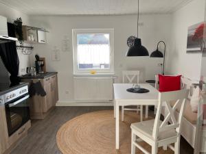 a kitchen with a white table and a table and chairs at Auszeit in Melsungen