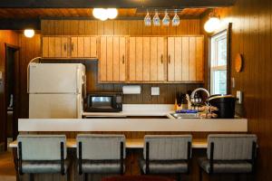 a kitchen with wooden cabinets and a white refrigerator at Creekside Chalet - Huge Indoor Spa in Bessemer