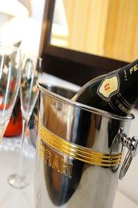 a bottle of wine in a bucket on a table with glasses at Hotel Sirius Riccione in Riccione