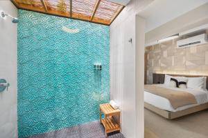 a bedroom with a bed and a bathroom with a wall at The Weekender Hotel in San Juan