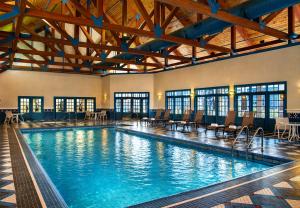 a large swimming pool with chairs in a building at Two Trees Inn in Ledyard Center