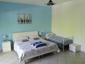 a bedroom with two beds and blue walls at Appartamento La Bonifica in Pescara