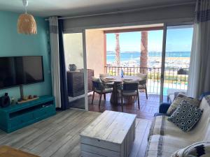 a living room with a television and a table with chairs at Blue Lagoon in Six-Fours-les-Plages