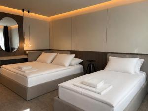 two beds sitting next to each other in a room at Wabi Hotel - Beauty & Dental Center in Sopron