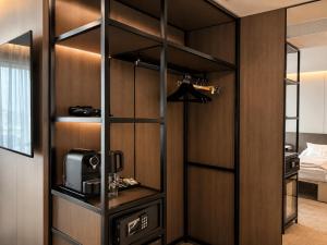 a room with a closet with a microwave and a bed at Wabi Hotel - Beauty & Dental Center in Sopron