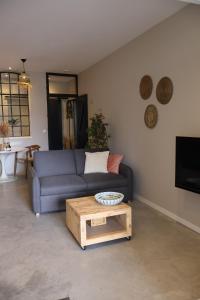 a living room with a blue couch and a coffee table at B&B de Beurtvaart in Dokkum