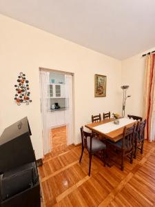 a dining room with a table and chairs and a television at Ljubez Apartment in Jajce