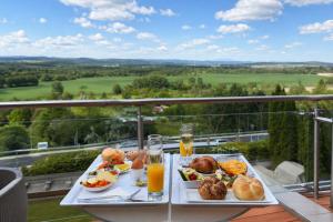 a table with two plates of food and orange juice at Wabi Hotel - Beauty & Dental Center in Sopron +21 photos