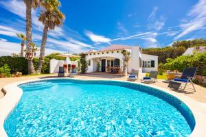 a swimming pool in front of a villa at Villa Miguel Dos in Cala en Bosc