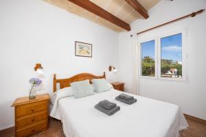 a bedroom with a white bed and a window at Villa Miguel Dos in Cala en Bosc +25 photos